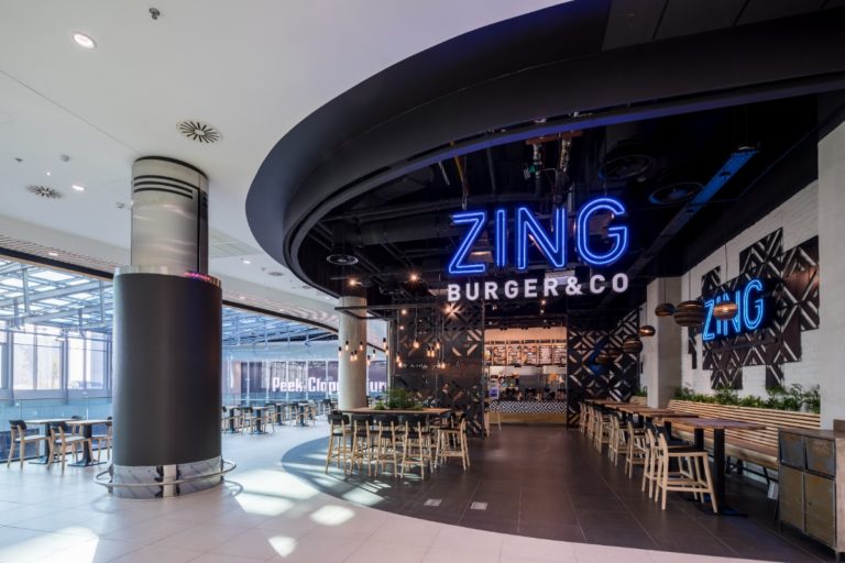 Indusztriális éttermi bútorok és fa burkolatok a Zing Burger modern belső terében.